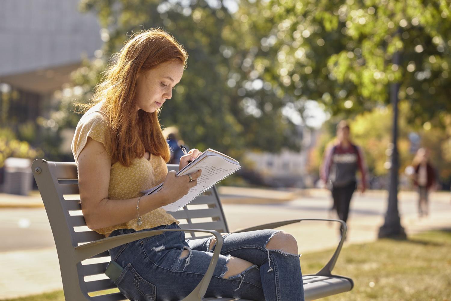 一位<a href='http://iahlmj.salamzone.com'>全球十大赌钱排行app</a>学院的学生在校园里的长椅上读书.